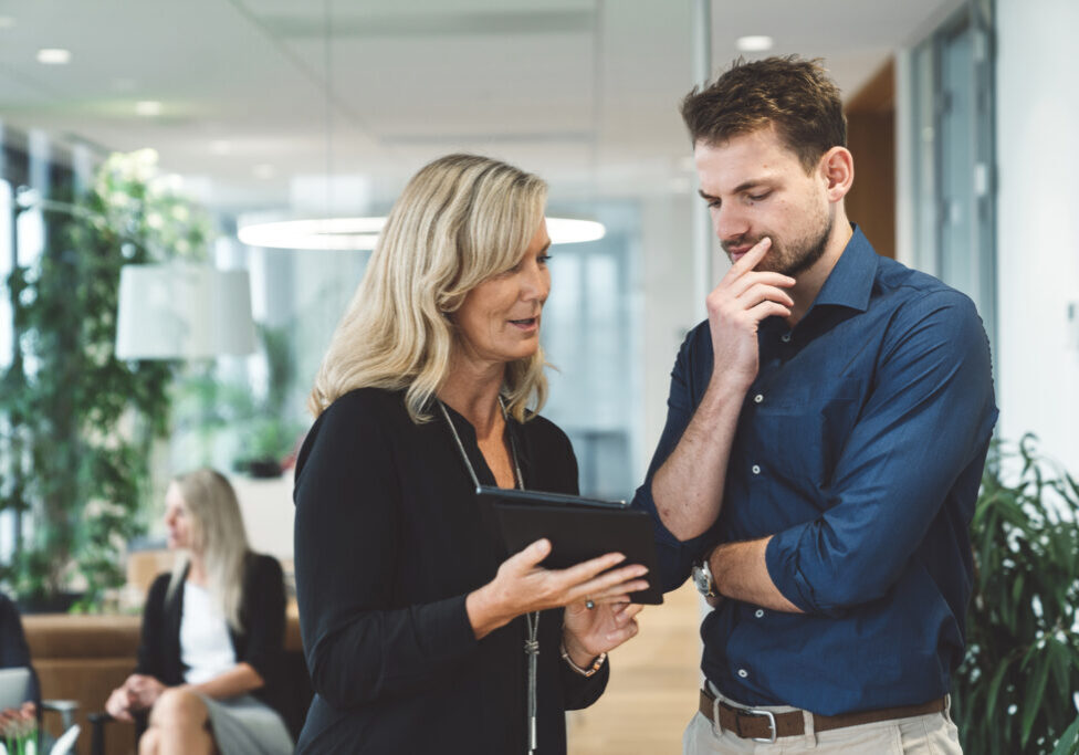blonde-woman-director-giving-a-task-to-a-young-bus-2026-01-07-06-45-55-utc