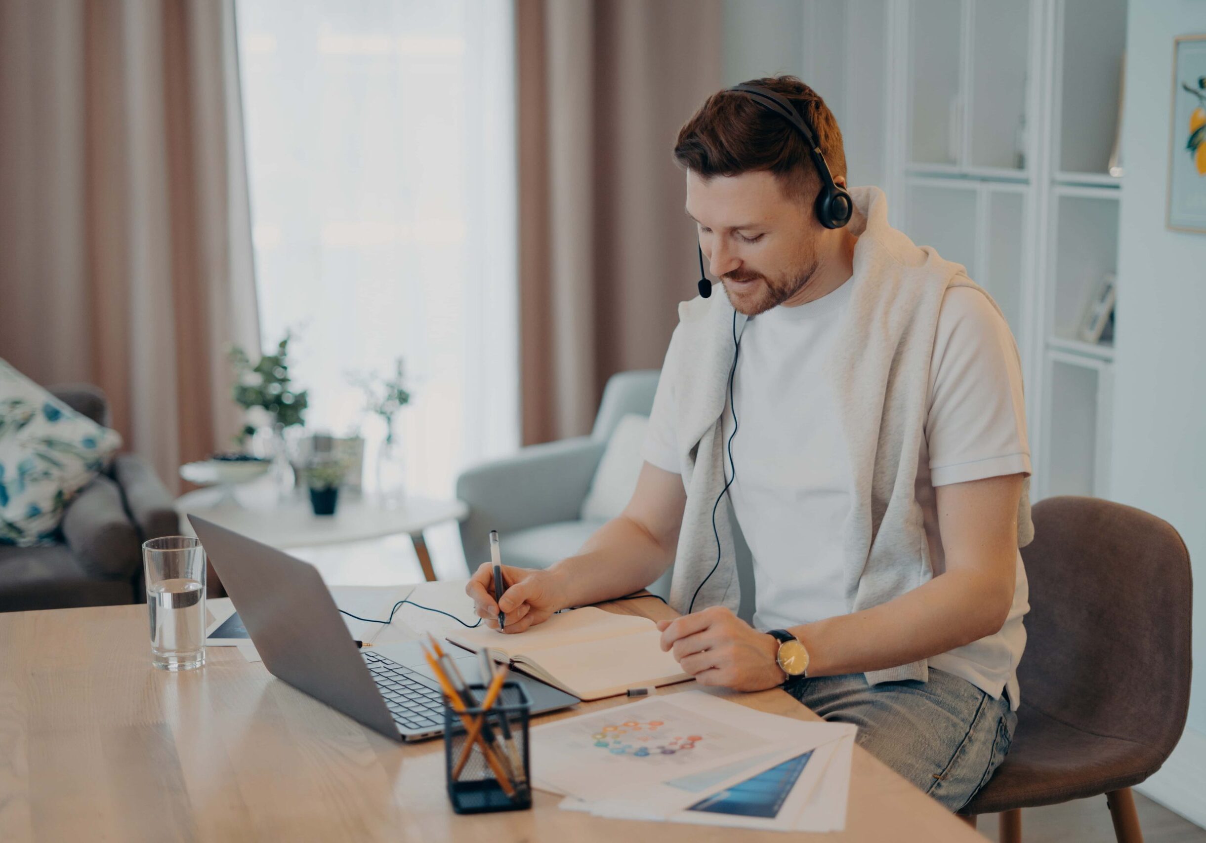indoor-shot-of-happy-male-makes-notes-while-listen-2022-07-28-04-01-25-utc